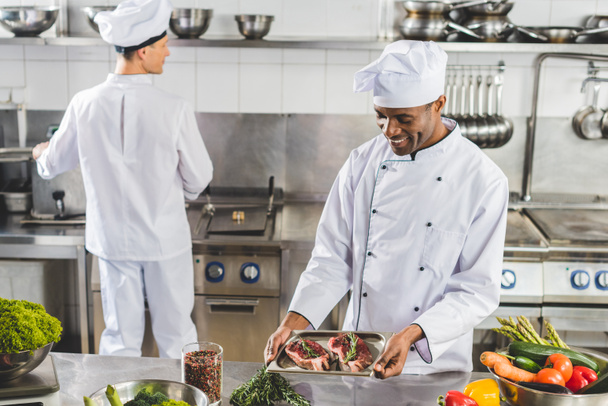 multicultural chefs cooking meat with vegetables at restaurant kitchen - Photo, Image