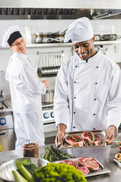 heureux chefs multiculturels cuisine steaks au restaurant cuisine
 - Photo, image
