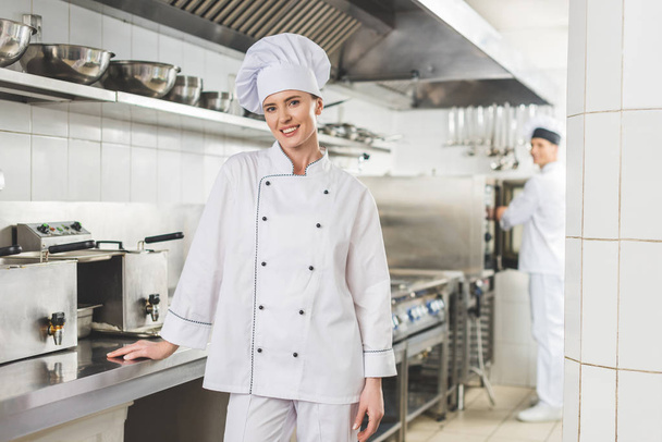 lachende chef-kok camera bij restaurant keuken kijken - Foto, afbeelding