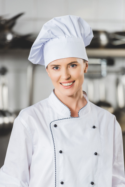 portrait of smiling attractive chef at restaurant kitchen - Fotó, kép