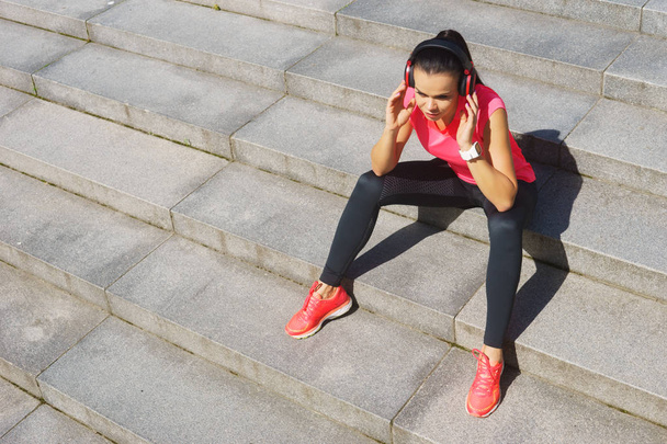 Young, fit and sporty woman preparing for urban jogging. Sport, fitness and healthy lifestyle concept. - 写真・画像