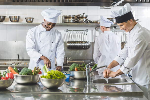 cuochi multiculturali che cucinano nella cucina del ristorante
 - Foto, immagini