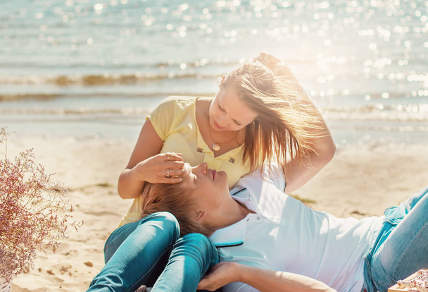 felice giovane coppia godendo pic-nic sulla spiaggia e hanno una buona ti
 - Foto, immagini
