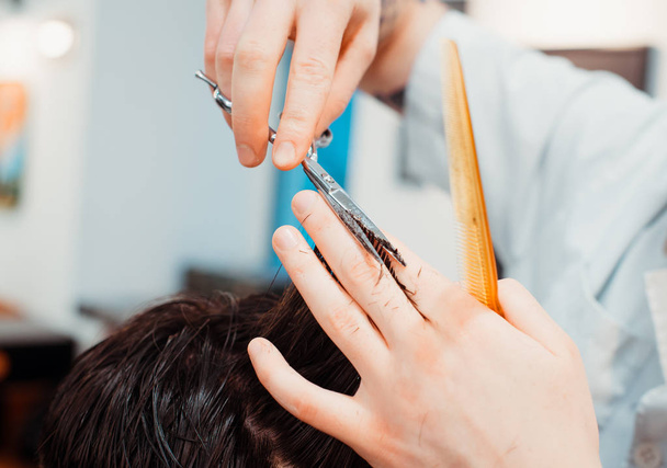 Mannen hairstyling en haircutting met haartrimmer in een kapper winkel of haar salon. Bebaarde brutale man in een kapper. - Foto, afbeelding