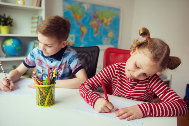 Two cute children drawing with colorful pencils  - Foto, afbeelding