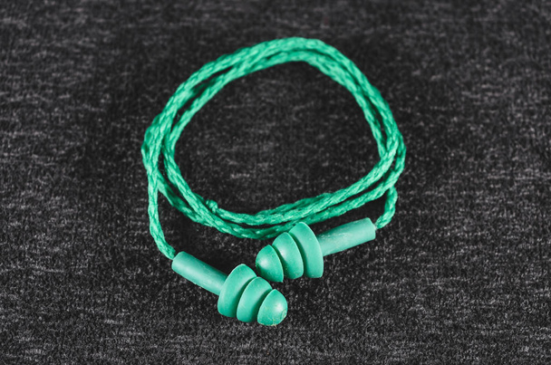 Bouchons d'oreille en caoutchouc pour l'isolation acoustique. Bouchon d'oreille vert avec cordon
 - Photo, image