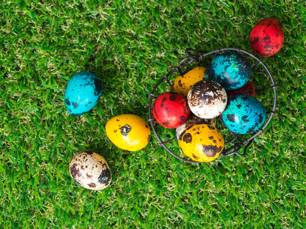 Many colorful of easter eggs are in the basket.A basket of Easter eggs placed on green grass. Easter day concept. - Zdjęcie, obraz