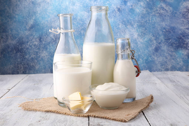 prodotti lattiero-caseari. latticini sani saporiti su un tavolo su. panna acida in una ciotola, ciotola di fiocchi di latte, crema in una banca e un vaso di latte, bottiglia di vetro e in un bicchiere
 - Foto, immagini