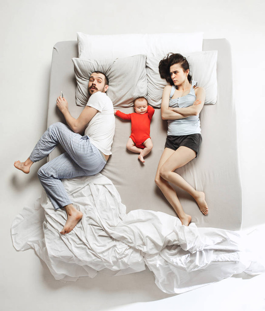 Top view of happy family with one newborn child in bedroom. - Foto, Imagen