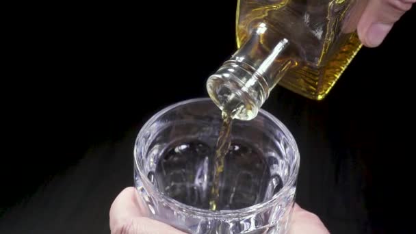 Mann gießt Whiskey aus Karaffe in Glas - Filmmaterial, Video