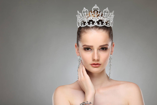 beautiful girl with crown on head posing on grey studio background - Foto, Bild