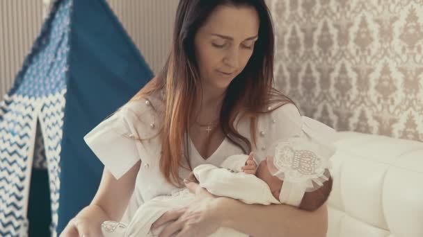 Adorable little newborn baby in mothers arms. Close up shot indoors - Metraje, vídeo