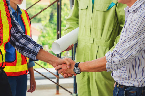 Deal, close up shaking hands of contractor, engineer and technician after finishing up business meeting to greeting start up project contract in construction site, partnership and teamwork concept - Foto, Imagen
