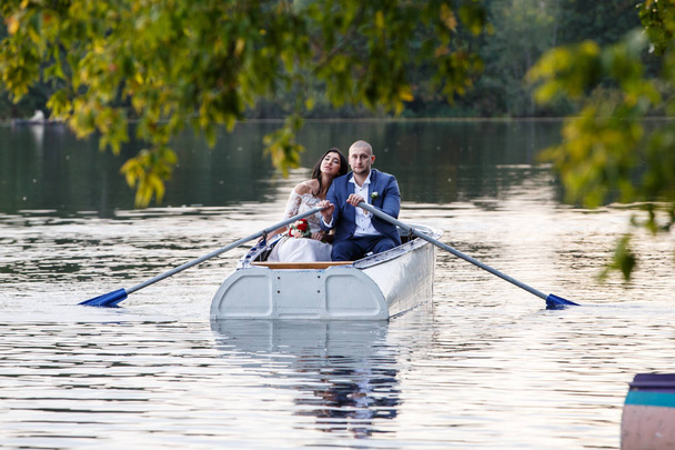 Молодая красивая пара обнимается, любит друг друга, расслабляется, катается на лодке
 - Фото, изображение