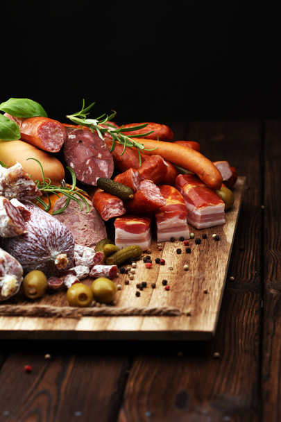 Food tray with delicious salami, ham,  fresh sausages, cucumber  - Foto, imagen