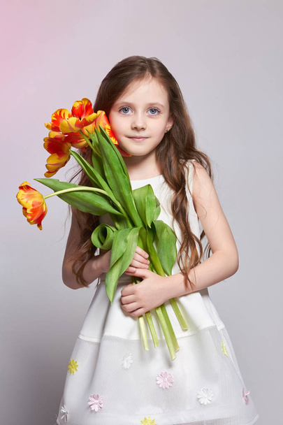Girl with big blue anime eyes and a bouquet of Tulip flowers in  - Fotoğraf, Görsel