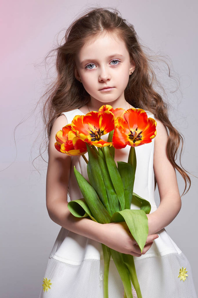 Girl with big blue anime eyes and a bouquet of Tulip flowers in  - Foto, Imagen