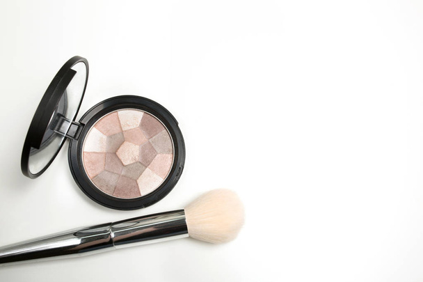 Pressed highlighter with makeup brush on a white background - Foto, imagen