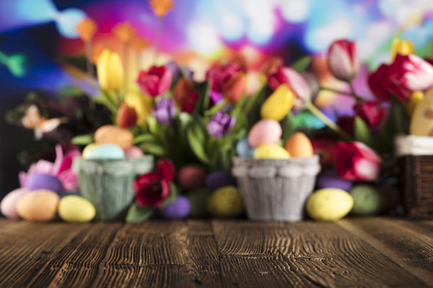 Easter theme. Easter eggs. Colorful tulips. Rustic wooden table. Shallow depth of focus. Bokeh background. Place for typhography. - Φωτογραφία, εικόνα