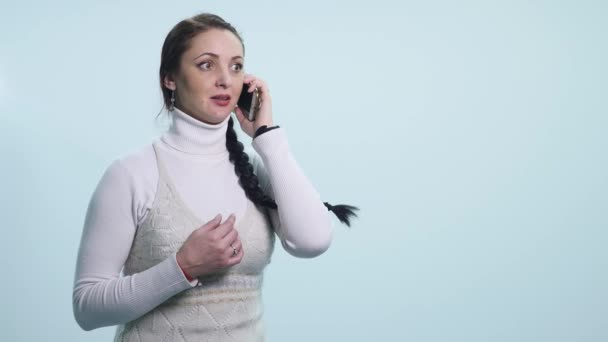 surprised young woman talking on mobile isolated over white - Filmagem, Vídeo