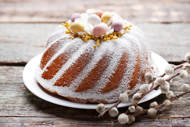 Easter cake in plate with tree branches on grey wooden table - Foto, immagini