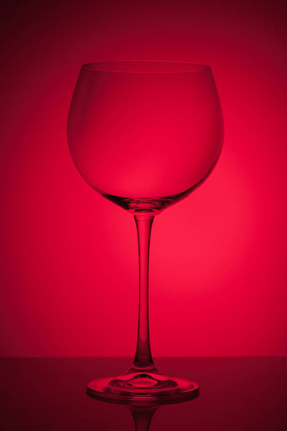 カラフルな抽象的な背景の空ワイン グラス. - 写真・画像