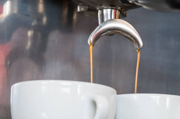 Espresso dripping from portafilter of coffee machine into white cup - Photo, Image