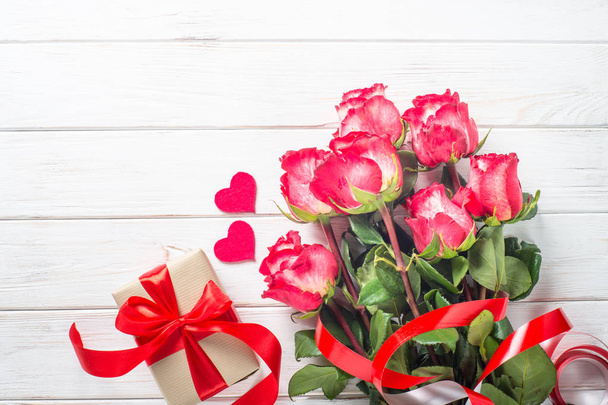 Червона троянда квітка і подарункова коробка на дерев'яному столі
.  - Фото, зображення
