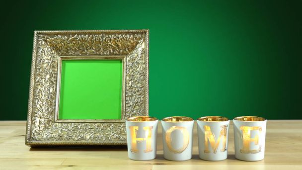 Antique photo frame with green screen and burning home candles. - Photo, Image