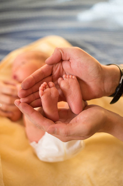 Pieds de bébé entre les mains du père. Gros plan
 - Photo, image