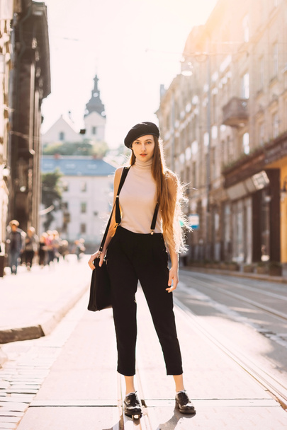 a girl with long hair and black and white clothes standing on th - Zdjęcie, obraz