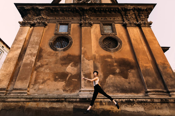 girl in the air during a jump against a background of a building - Foto, afbeelding