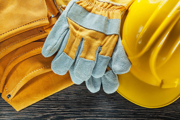 Leather tool belt hard hat pair of safety gloves on wooden board - Φωτογραφία, εικόνα