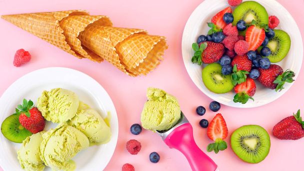 helado de té verde matcha con conos de gofre y fruta fresca en la superficie plana laico
. - Foto, imagen