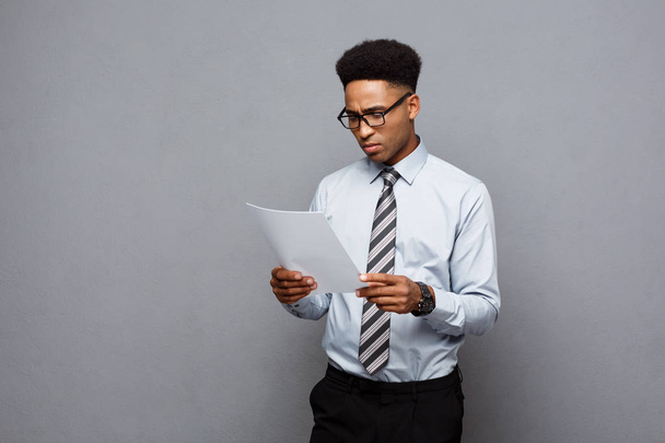 Koncepcja biznesowa - przystojny młody profesjonalne Afryki amerykański biznesmen koncentruje się czytanie na papierze. - Zdjęcie, obraz