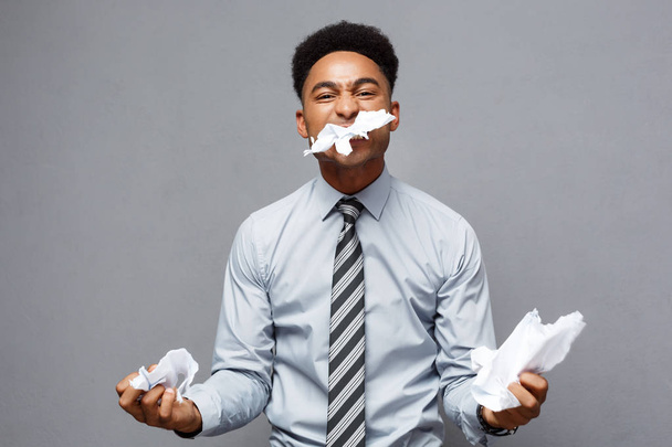 Üzleti koncepció - dühös fiatal afro-amerikai üzletember, balled evés közben a papír jelentést. Sikertelen projekt.  - Fotó, kép