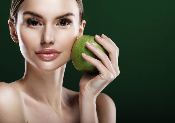 Young woman with  green apple over green background - Photo, image