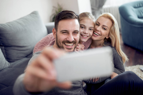 Aile selfie onların oturma odasında yapıyor. Aşk, Aile, teknolojisi, Internet ve insanlar kavramı. - Fotoğraf, Görsel