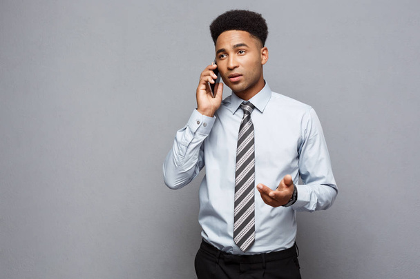 Businessconcept - vrolijke professionele Afro-Amerikaanse zakenman gelukkig praten op mobiele telefoon met klant. - Foto, afbeelding