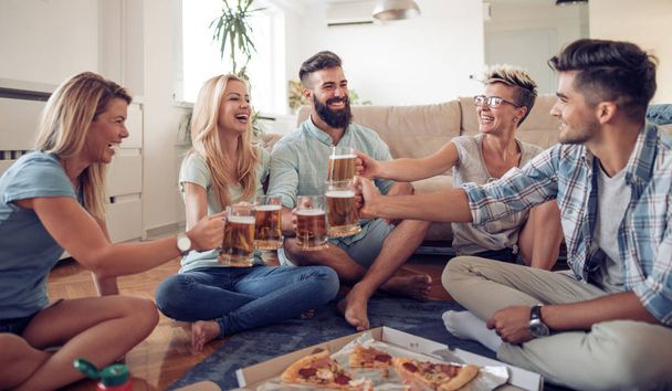 Grupo de jóvenes juguetones comiendo pizza mientras se divierten juntos
. - Foto, imagen