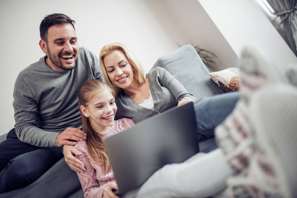Família passando tempo juntos em casa, assistindo filme no laptop
. - Foto, Imagem