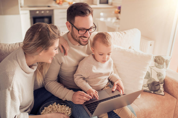 Portrait of a joyful family using a laptop - Foto, Imagen
