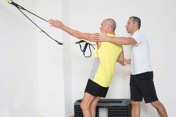 Man helps with suspension training - Photo, Image