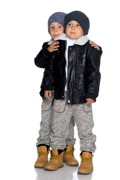 Two little boys in black jackets and hats. - 写真・画像
