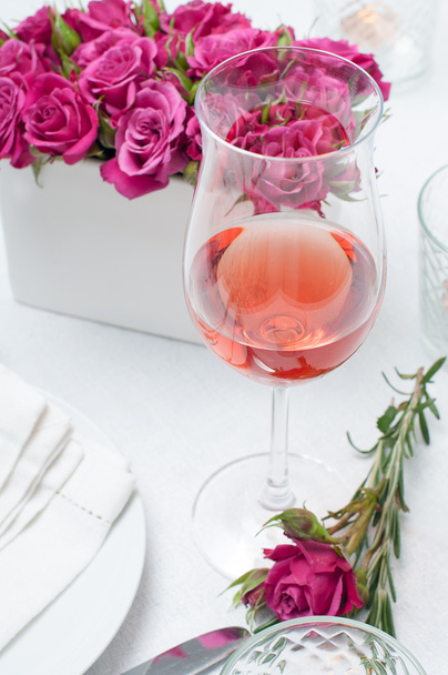 glass of rose wine and festive dining table setting with pink ro - Фото, зображення