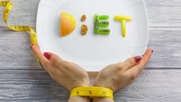 ovoce na talíři slovo dieta, jablko, kiwi, mrkev, ořechy - Fotografie, Obrázek