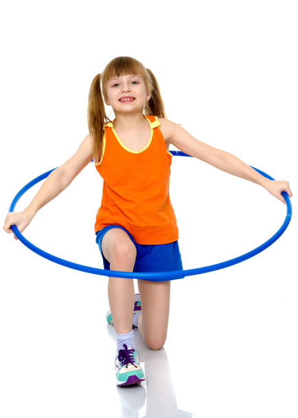 A girl gymnast performs an exercise with a hoop. - Φωτογραφία, εικόνα