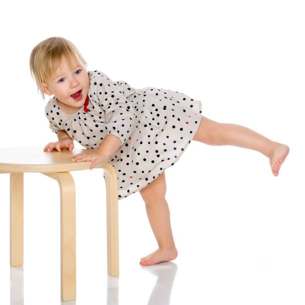 Little girl is sitting on a chair - Foto, afbeelding