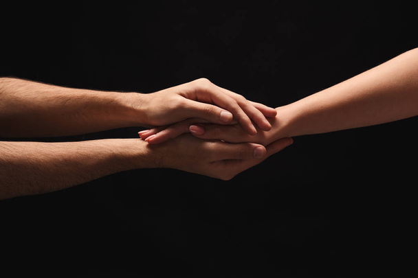 Руки чоловіка і жінки в любові, ізольовані на чорному
 - Фото, зображення