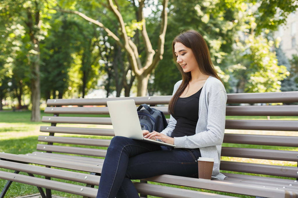 Mujer joven feliz con ordenador portátil al aire libre
 - Foto, Imagen